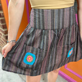 A woman wearing the agate Granny Square Mini Skirt with a tan top.