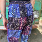 A woman wearing the Cotton Block Print Batik Cutwork Pants in front of a vintage Volkswagen bus.