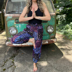 A woman wearing the Cotton Block Print Batik Cutwork Pants in front of a vintage Volkswagen bus.