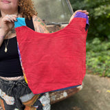 An up-close image of someone holding the Cotton Tie Dye Cat Crossbody Bag in front of a vintage Volkswagen bus.