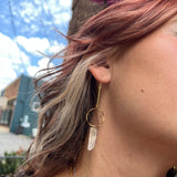 Someone wearing the brass Quartz Crystal Drop Earrings.