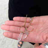 Someone is holding the brass Quartz Crystal Drop Earrings.