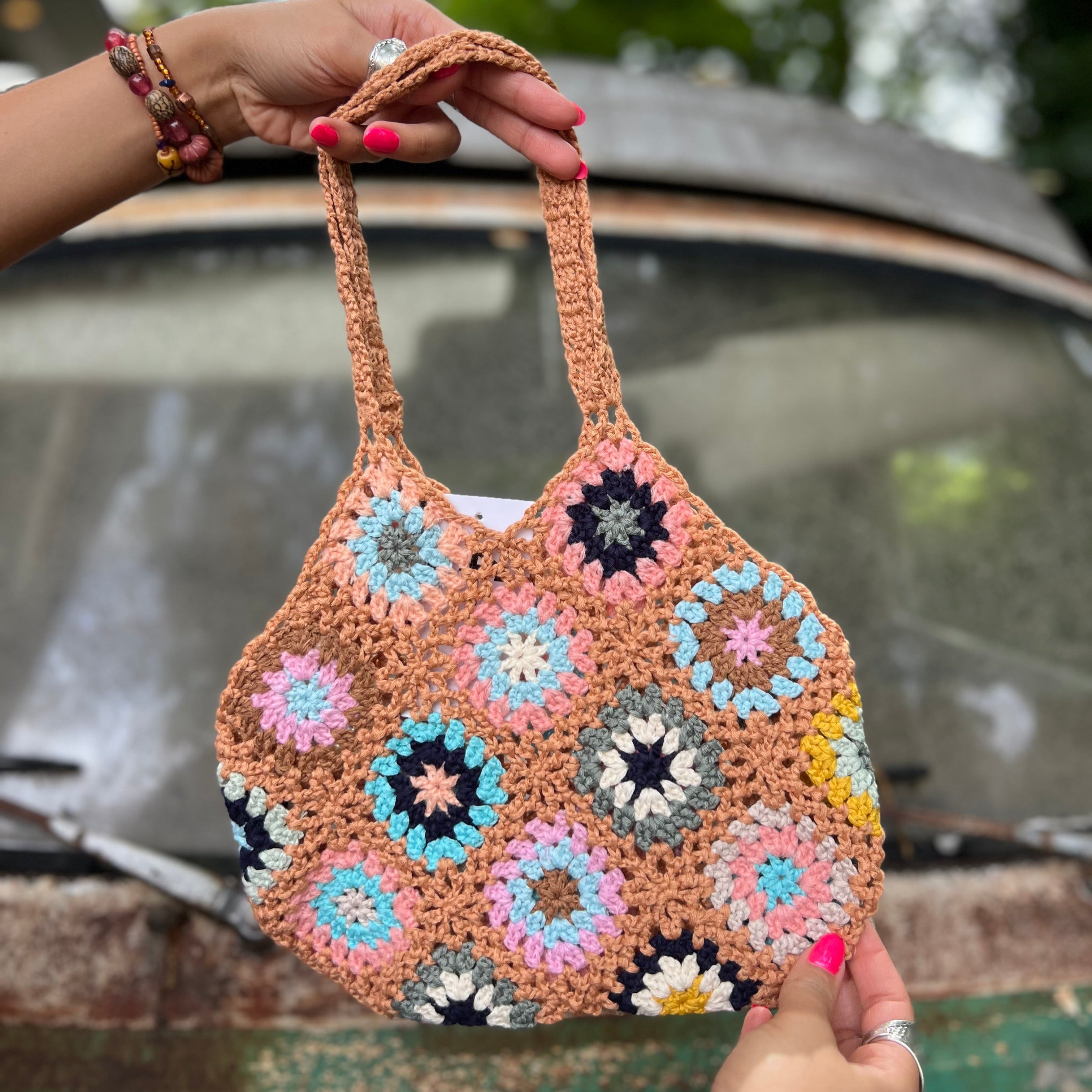 Someone holding the khaki Bohemian Handmade Crochet Bag in front of an old teal Volkswagen bus.