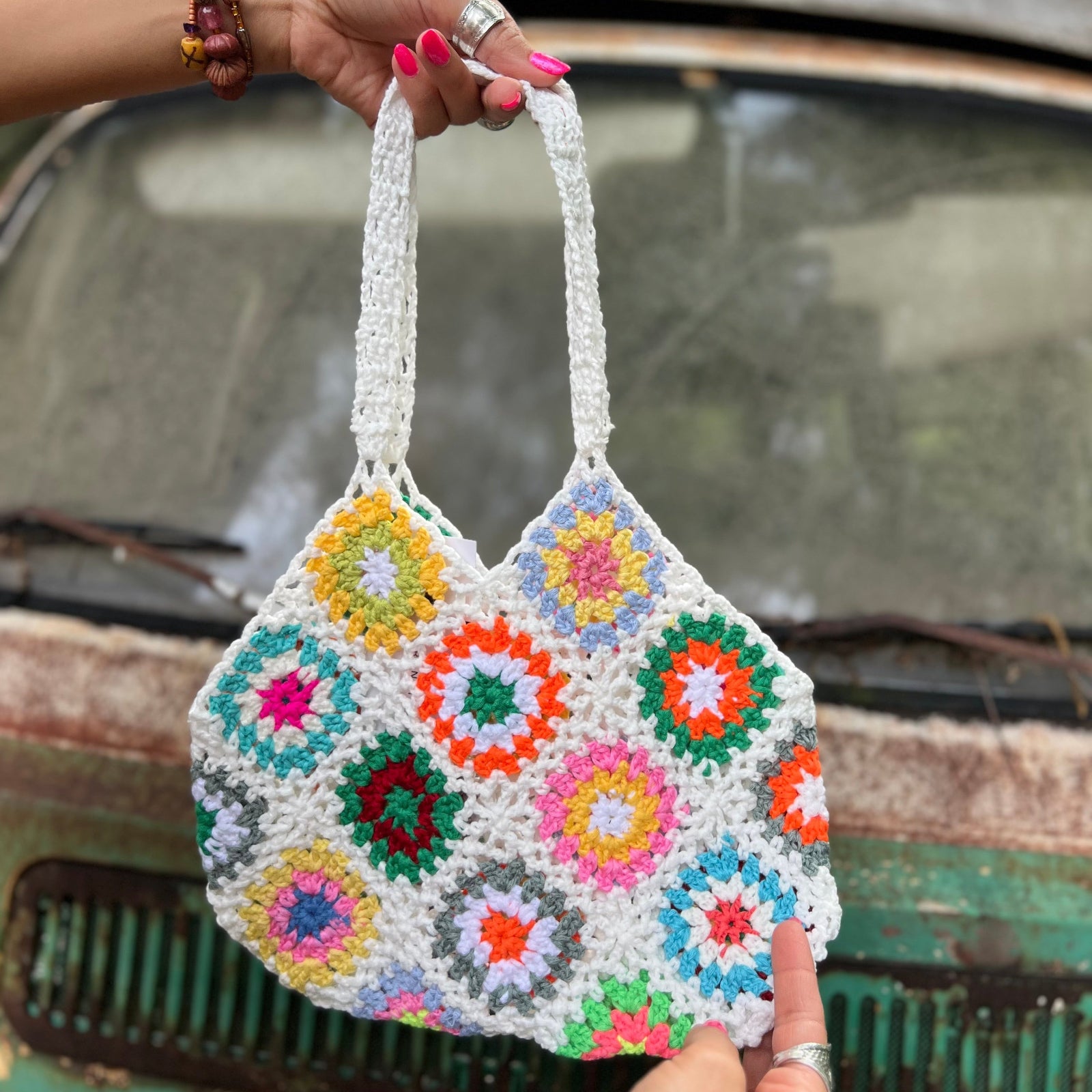 Someone holding the white Bohemian Handmade Crochet Bag in front of an old teal Volkswagen bus.