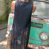 A woman wearing the black Faux Suede Long Fringe Western Vest.