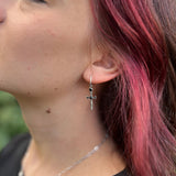 A woman wearing the Silver Sword Hoop Earrings.