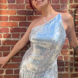 A woman wearing the Silver Sequin Disco Dress in front of a brick building.
