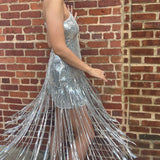 A woman wearing the Silver Sequin Disco Dress in front of a brick building.