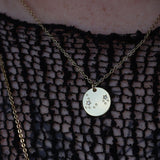 Someone wearing the Pisces 14k Gold Dipped Nickel-Free Zodiac Necklace with a black net top.