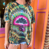 Model posing outside with handmade tie-dye shirt in festival colors