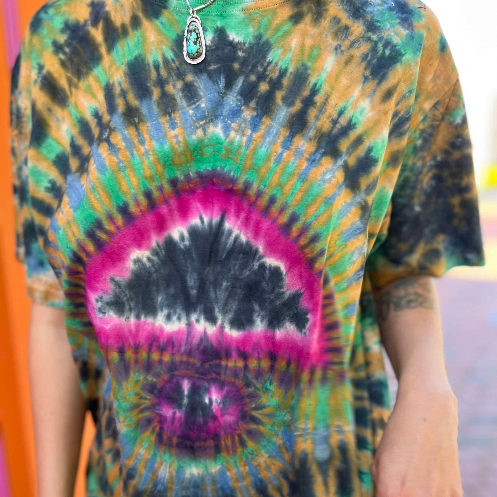 Detail view of tie-dye mandala pattern with mushroom and peace vibes