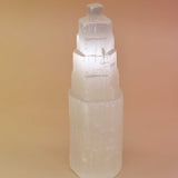 Crystal tower with 'Selenite' text on a beige background