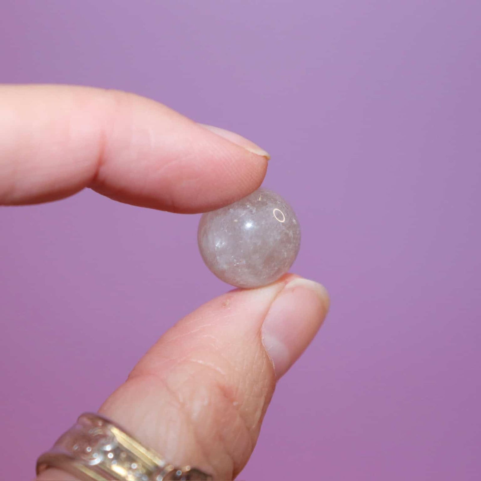 hand holding a smoky quartz crystal marble