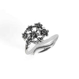 Silver ring with floral design on a white background