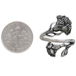 Silver floral ring next to a dime for size comparison on a white background