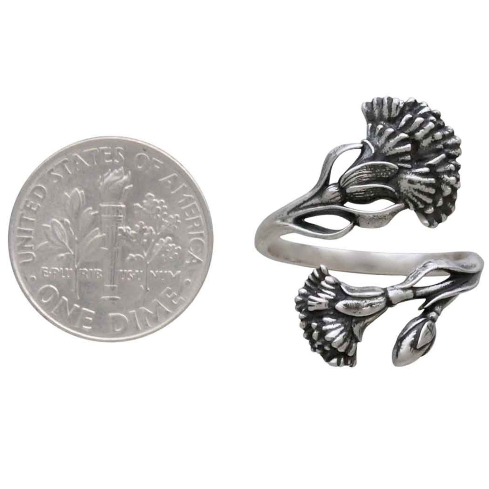 Silver floral ring next to a dime for size comparison on a white background
