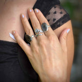 Close-up of a hand wearing multiple rings with a blurred background