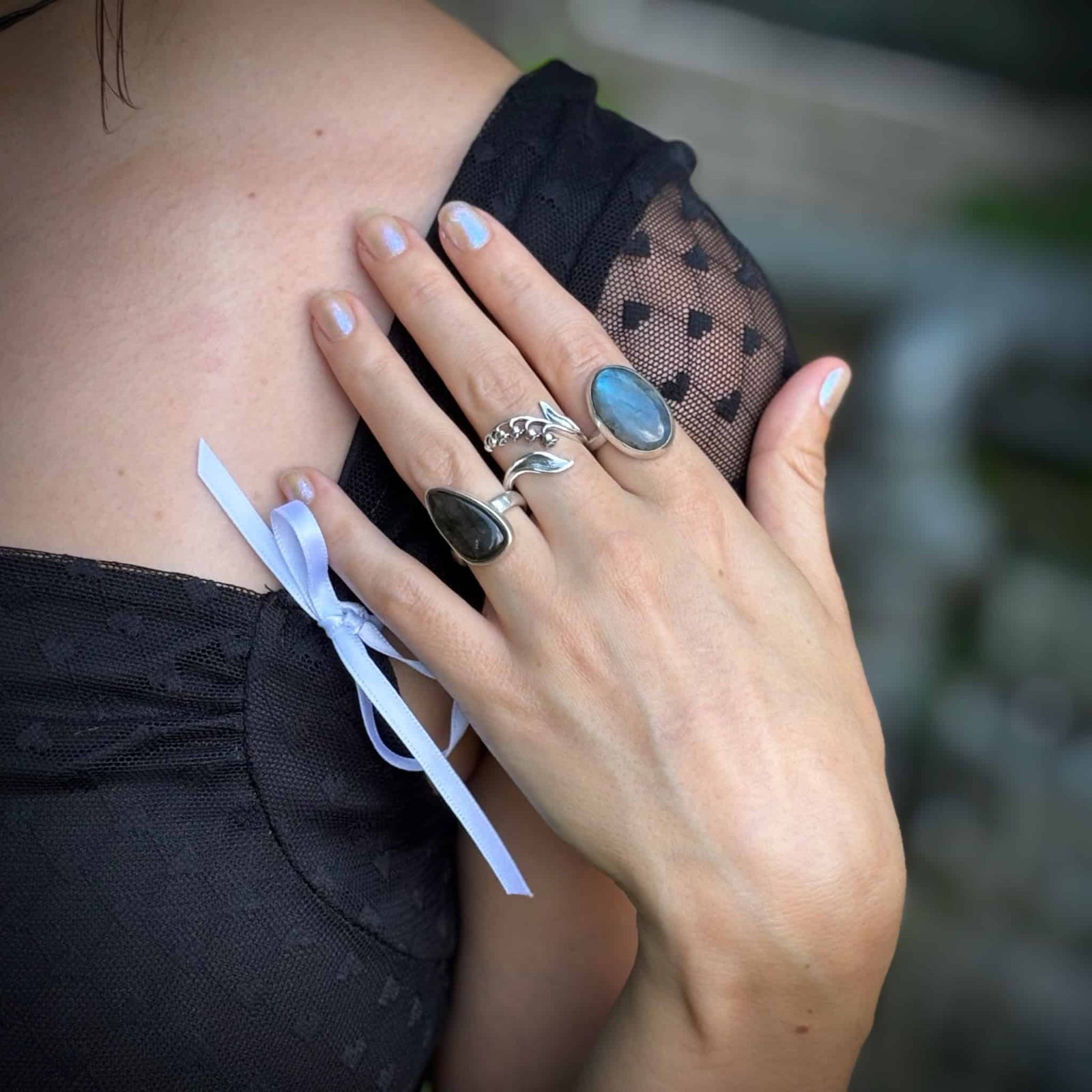 Close-up of a hand with multiple rings on a blurred background