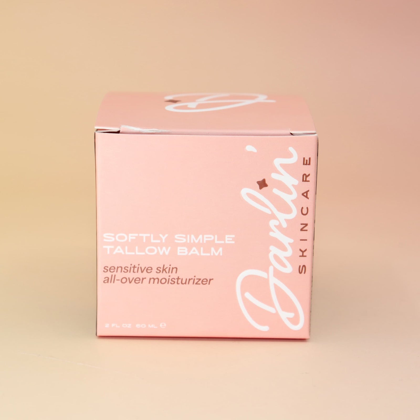 Pink box of Darlin Skincare Tallow Balm on a beige background