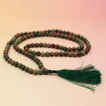 Unakite 108 Mala Necklace on pink and orange background