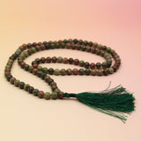 Unakite 108 Mala Necklace on pink and orange background