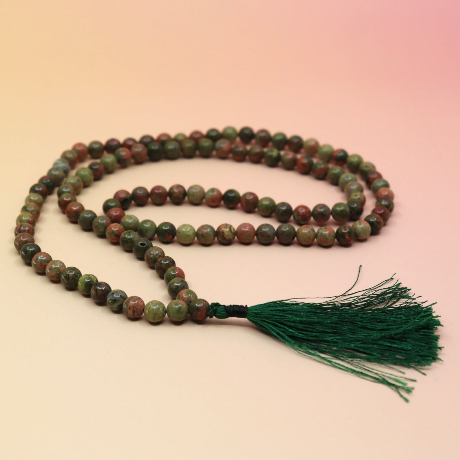 Unakite 108 Mala Necklace on pink and orange background