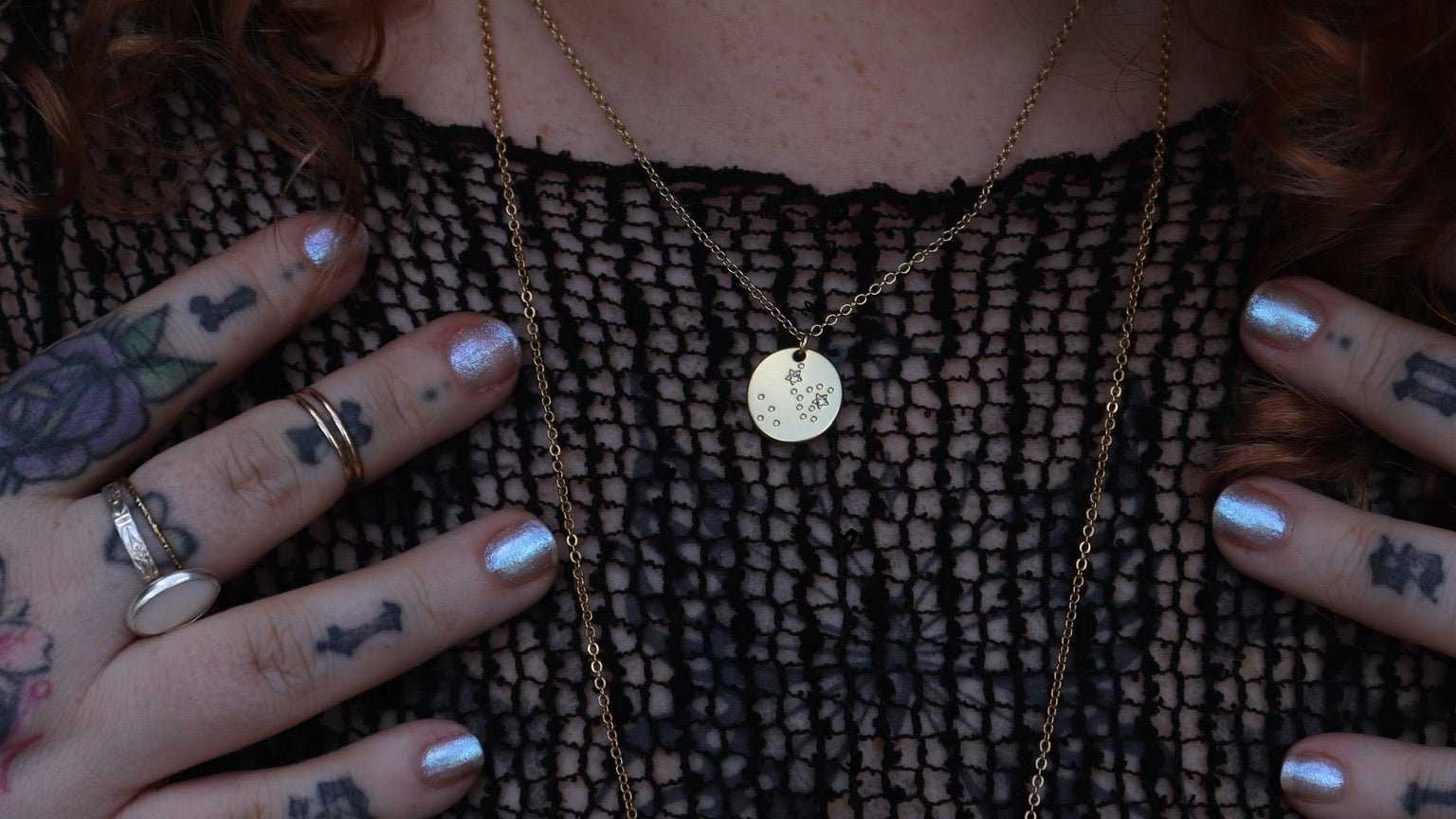 Someone wearing the Sagittarius 14k Gold Dipped Nickel-Free Zodiac Necklace with a black net top.