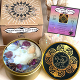 The Scorpio Crystal Candle opened with the lid to the right of it. The packaging of the Scorpio Crystal Candle is behind the candle next to a card.