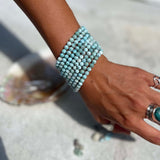 Larimar beaded bracelet on a wrist with a blurred background