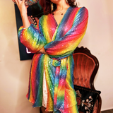 A woman wearing the Disco Rainbow Wrap Dress while holding a disco ball.