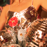 Someone wearing the Sequin Flower Embellished Crop Cami with jeans.