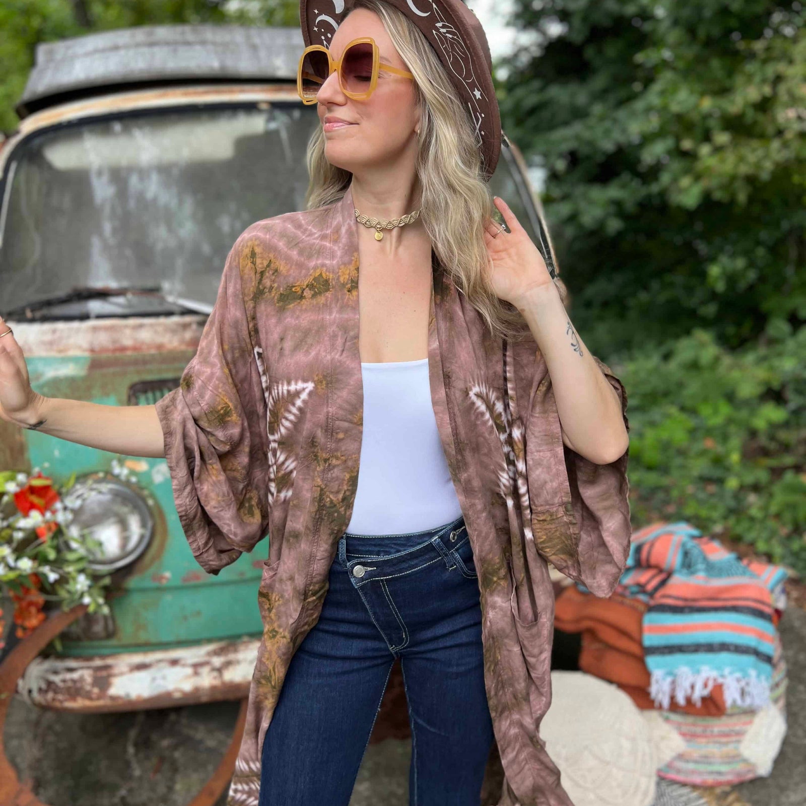 Woman wearing a patterned kimono and cowboy hat in front of a vintage truck.