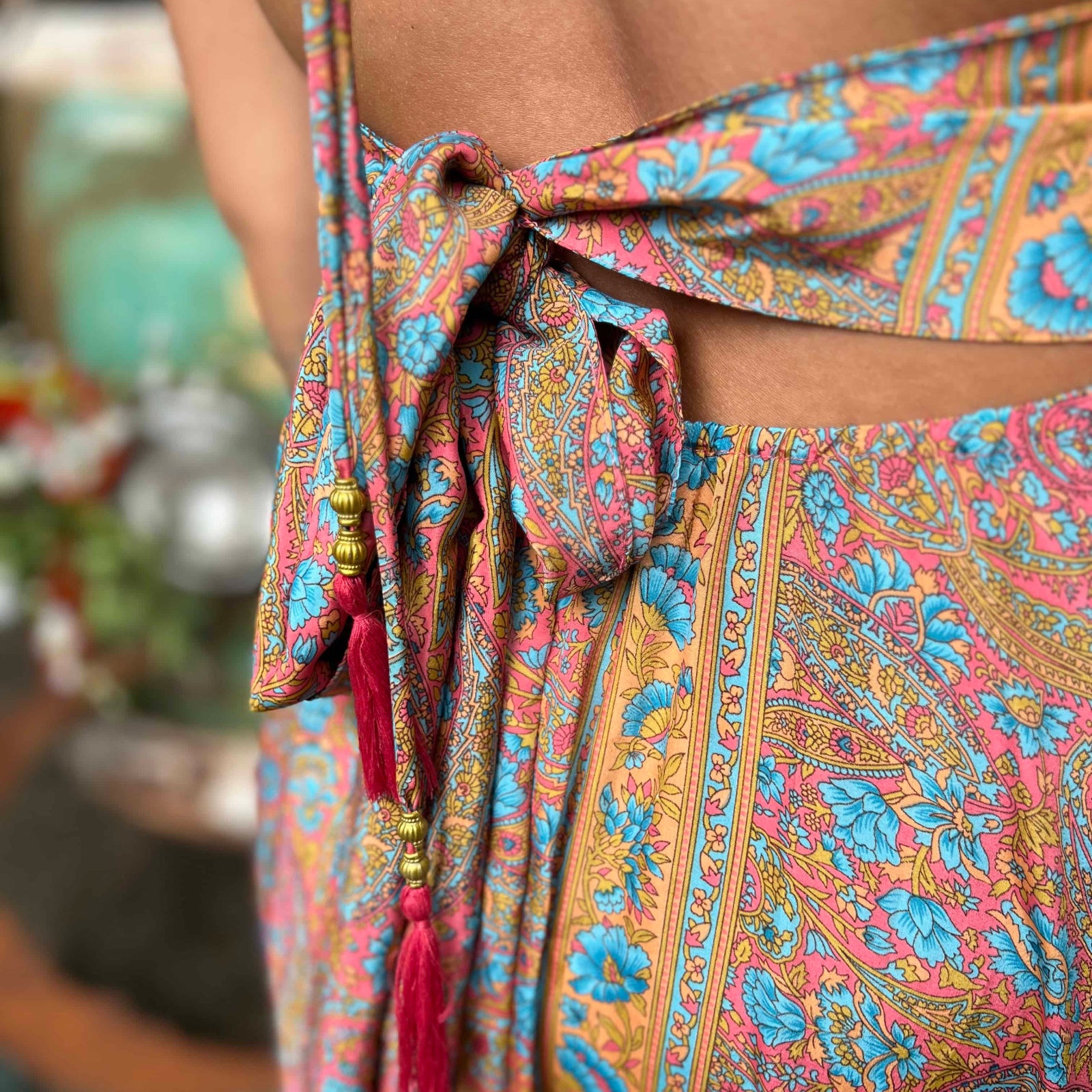 Model posing in silk boho maxi dress with bow tie back