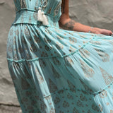 Light blue dress with intricate patterns and tassel details against a neutral background
