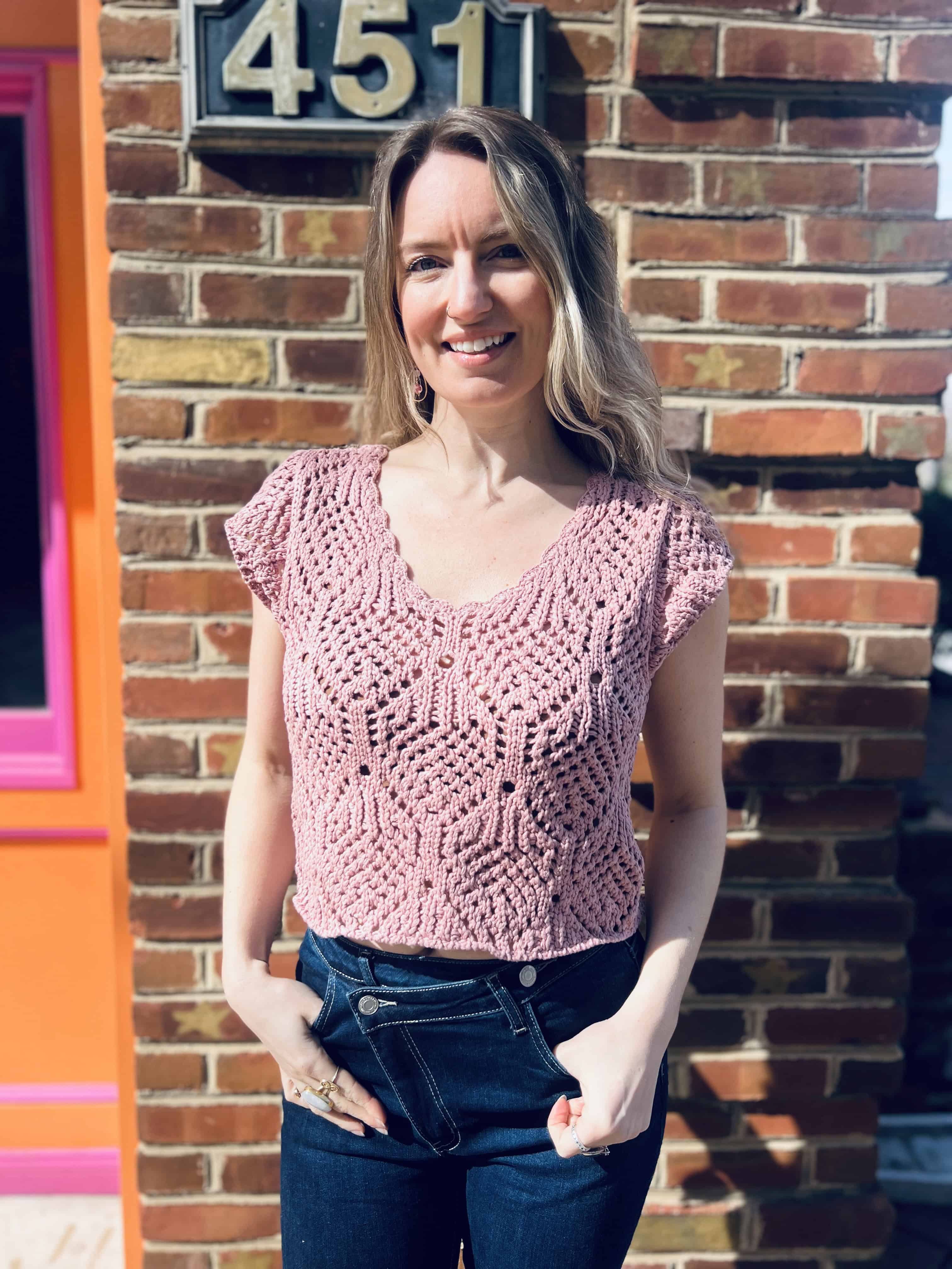 close up of a lightweight crochet knit detailing on a cotton v-neck cap sleeve top standing in front of the boho depot retail store