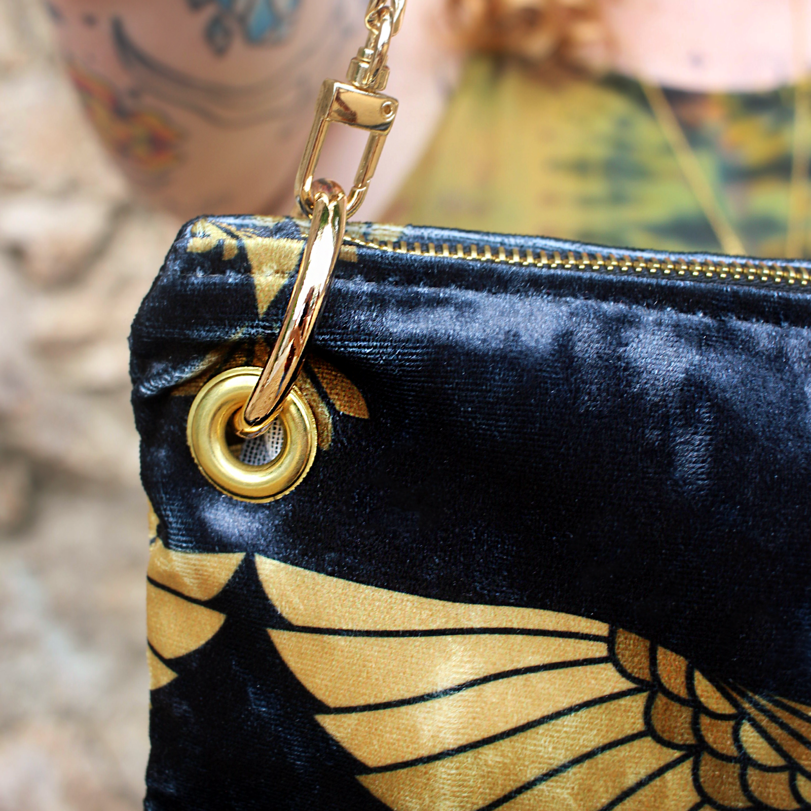 An up close image of a woman holding the Black and Gold Heron Chain Strap Velvet Crossbody Bag.