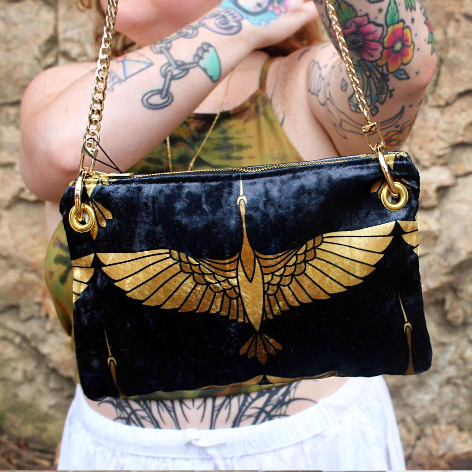 A woman holding the Black and Gold Heron Chain Strap Velvet Crossbody Bag.