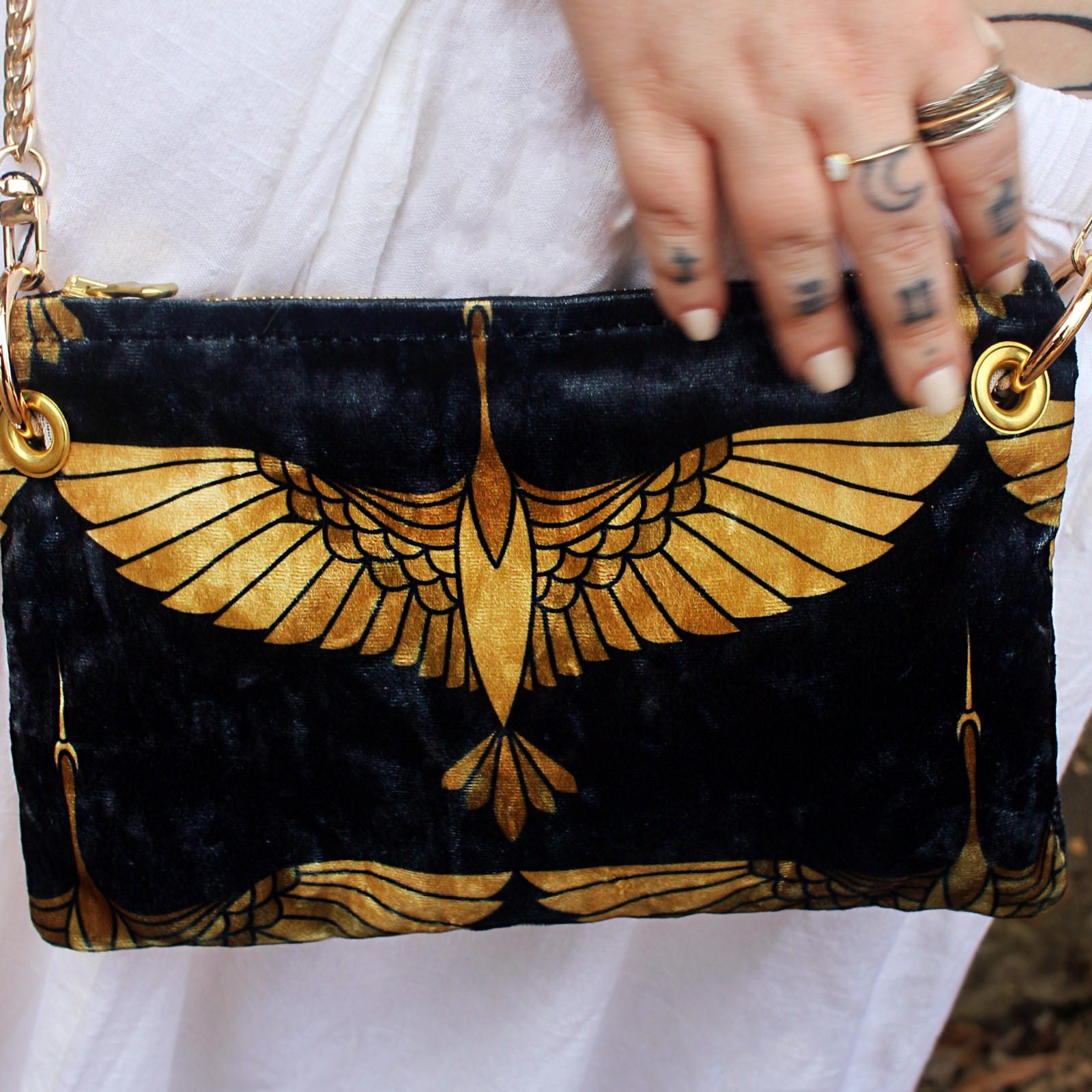 A woman holding the Black and Gold Heron Chain Strap Velvet Crossbody Bag.