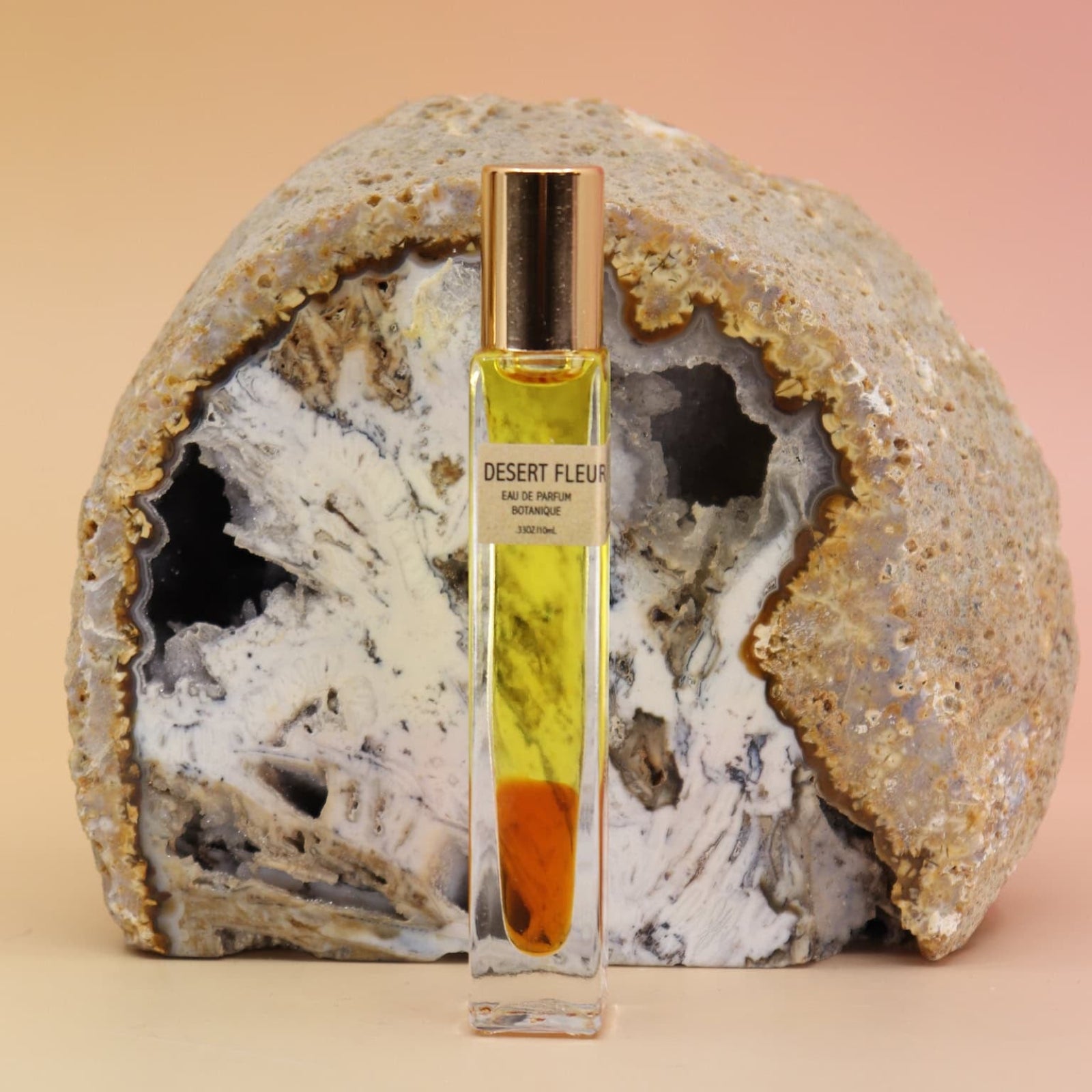 Desert Fleur Botanical Perfume rollerball – botanical fragrance with visible oil drop and geode backdrop
