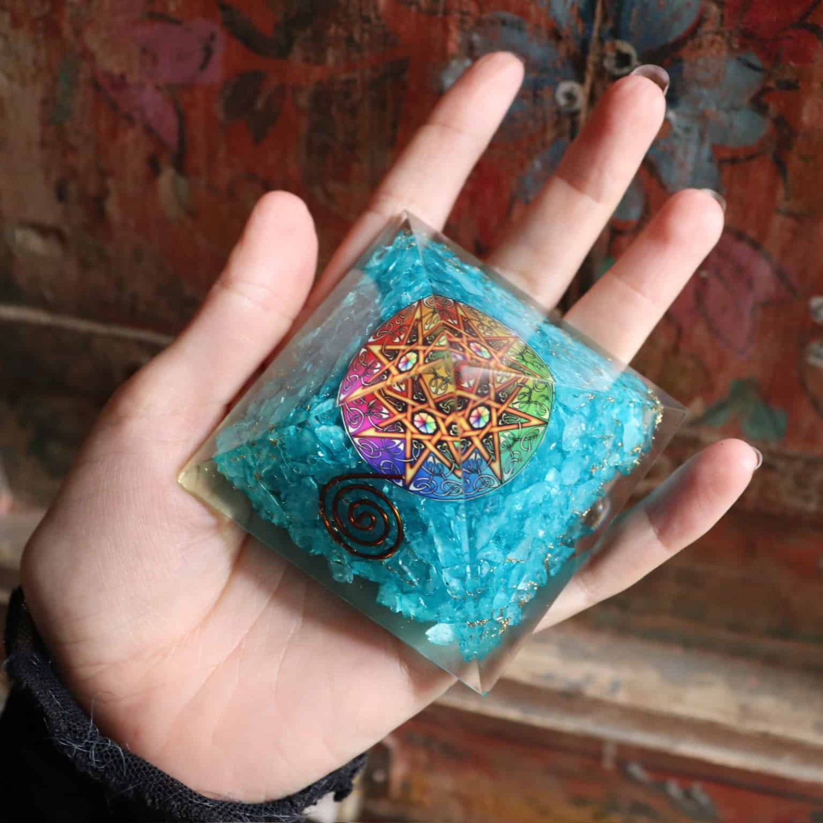 Top view of turquoise orgone pyramid with colorful chakra mandala
