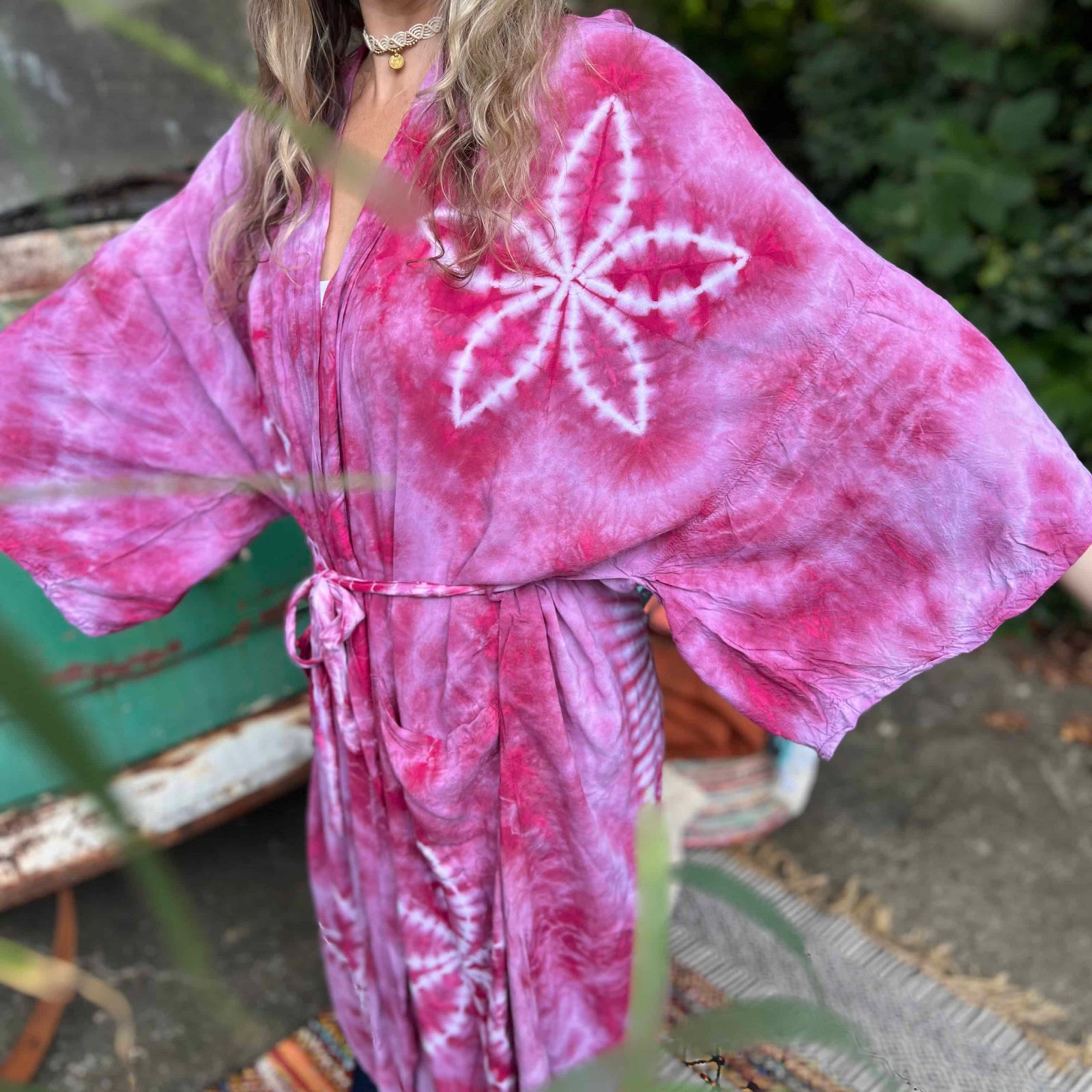 Close-up of lotus flower tie dye on green boho kimono