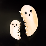 The Ghost Claw hair clips, both small and large, on a black background.