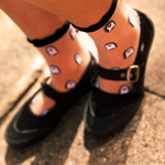 Someone wearing a pair of the Sheer Ruffle Ghost Socks with black mary janes!