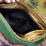 Someone holding the Chevron Vintage Green Velvet Crossbody Bag open to show off the inside.