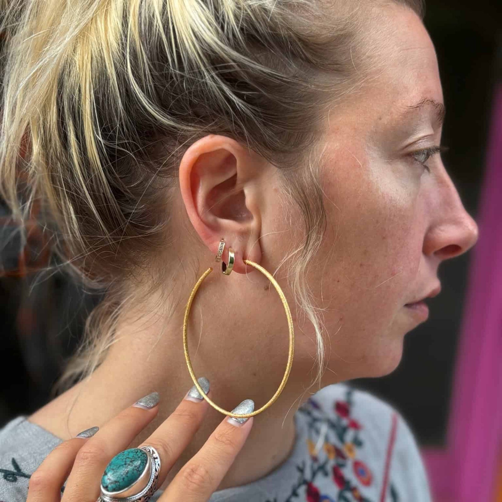Side profile of woman wearing Emma Pills large hoop earrings