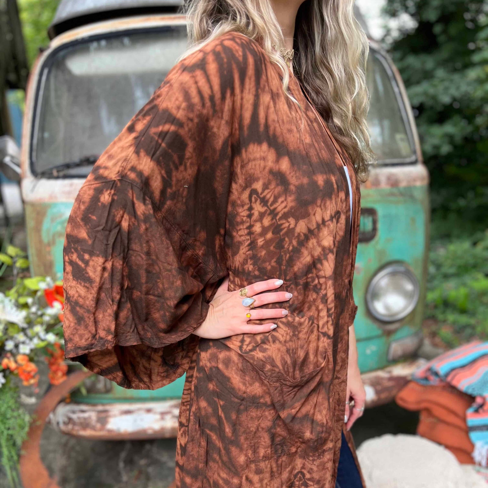 Person wearing a brown tie-dye kimono in front of a vintage van.