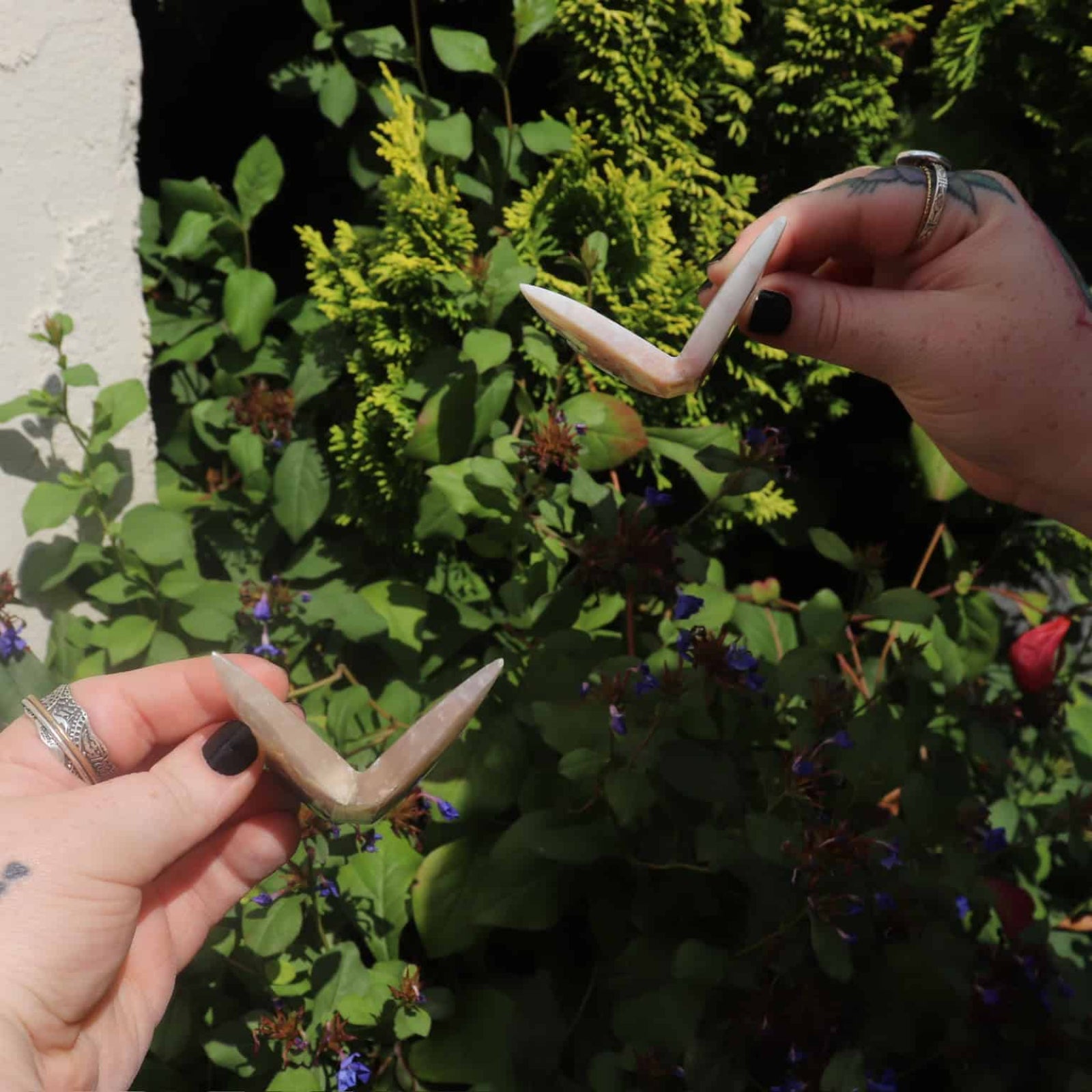 Pair of pink agate crystal butterflies displayed outdoors