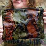 A woman holding the Bronze and Olive Snake Print Pouch showing the back.