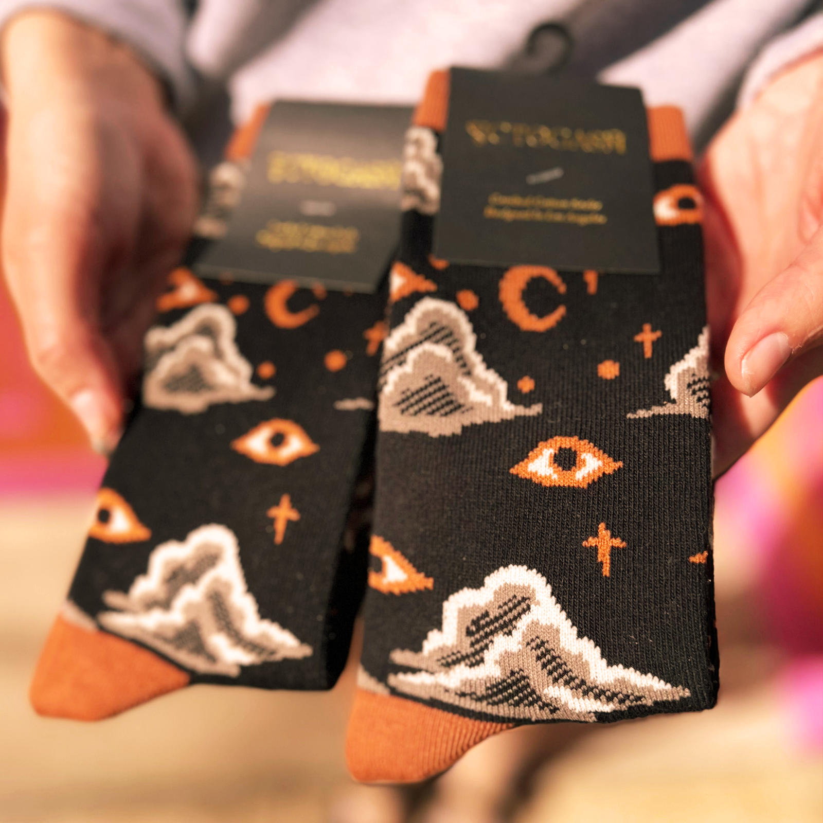 Someone holding two packs of the Starry Eyes Socks.