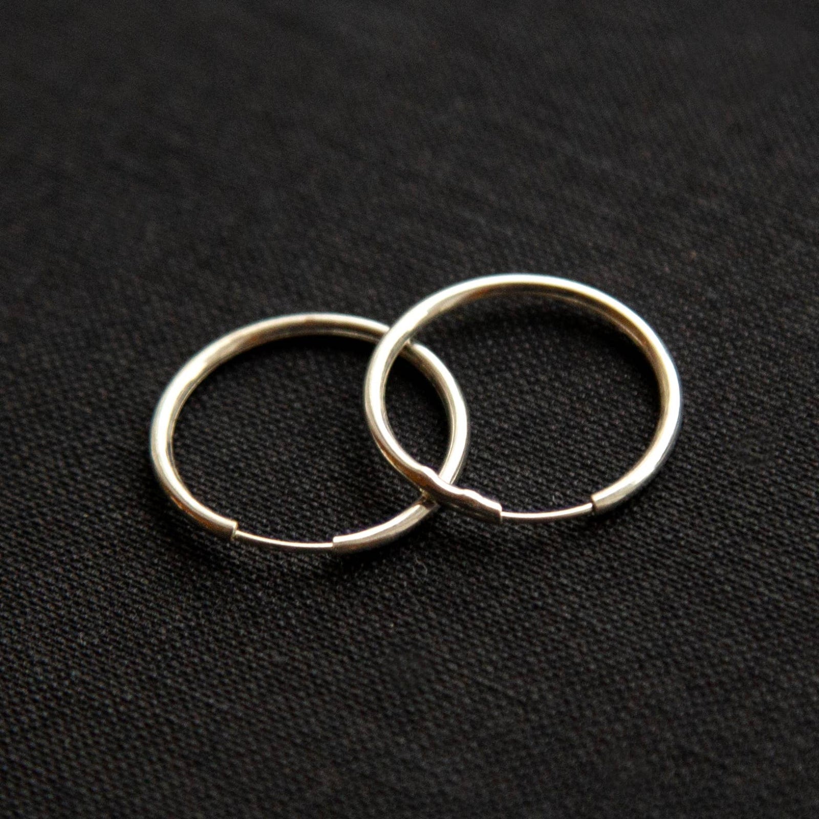 The silver Vintage Endless Hoops Earrings on a black background